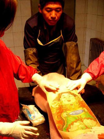农场内的十几头猪背上纹有各种风格图案,据介绍,国外的收藏家和画廊喜欢收藏这种纹身猪皮,一张价格最高可达100万元。